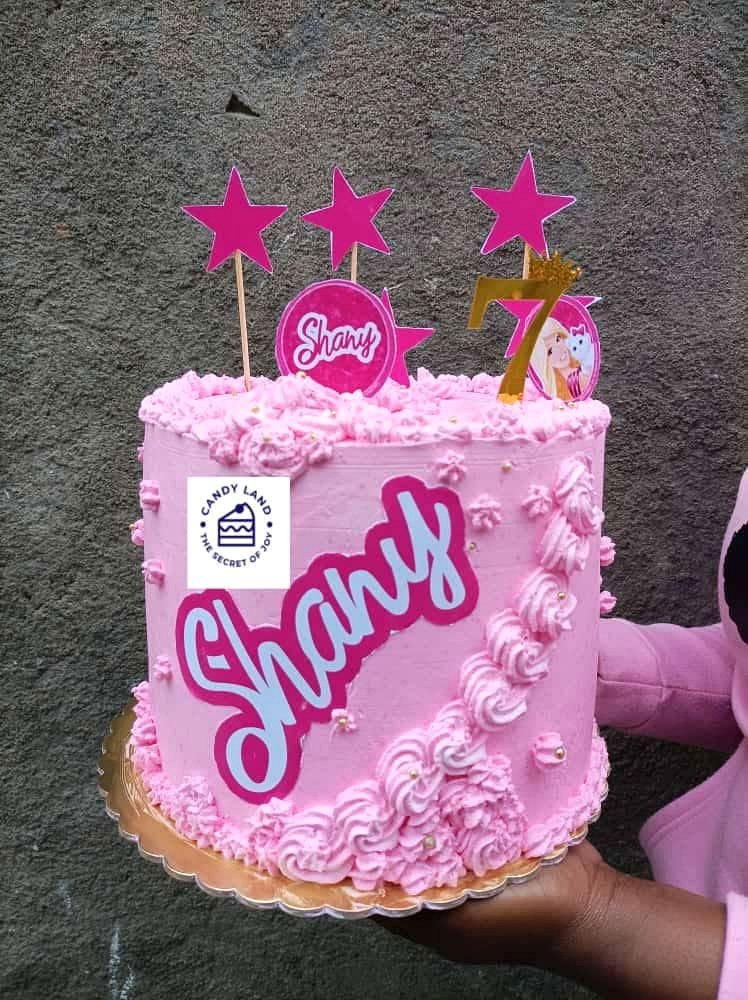 Bolo rosa de aniversário com o número 7 e decoração de estrelas